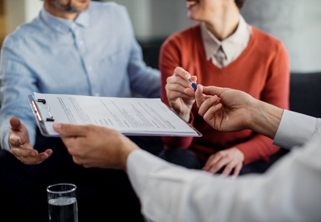 closeup-unrecognizable-couple-signing-contract-with-financial-advisor.jpg